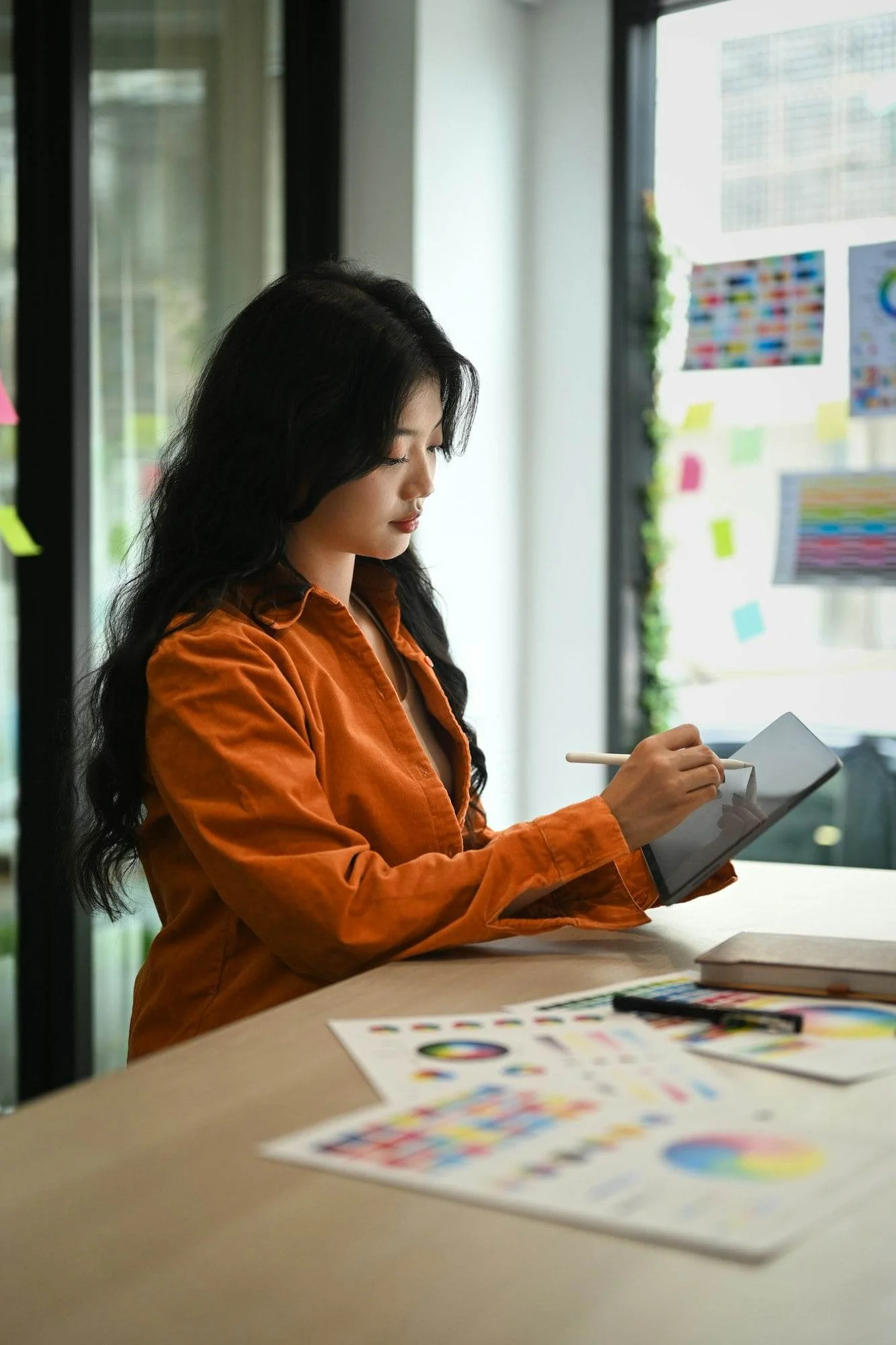 Asian female graphic designer working on new design project at creative office